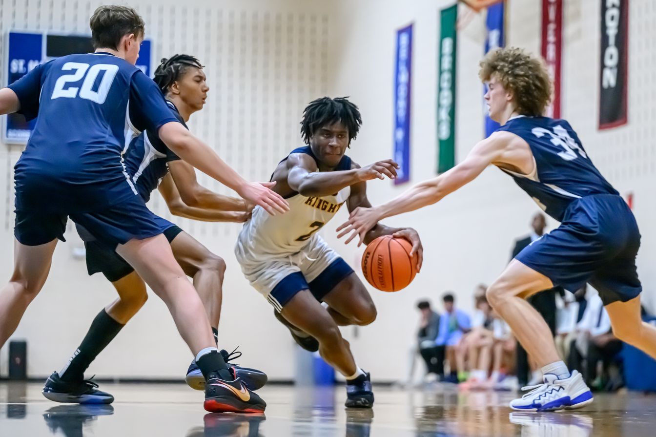 A group of young men playing basketball in a gym.