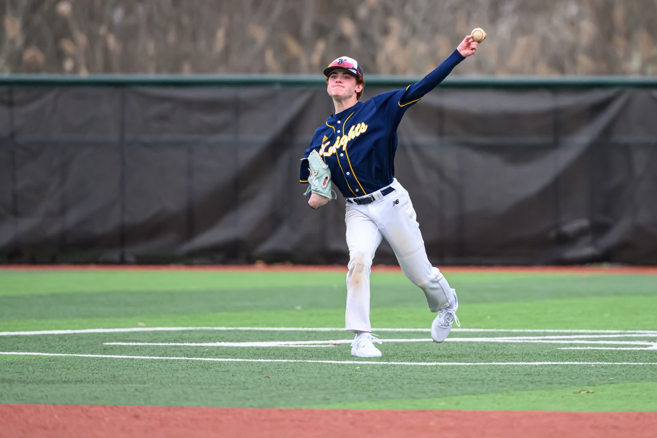 boy throwing baseball on field.