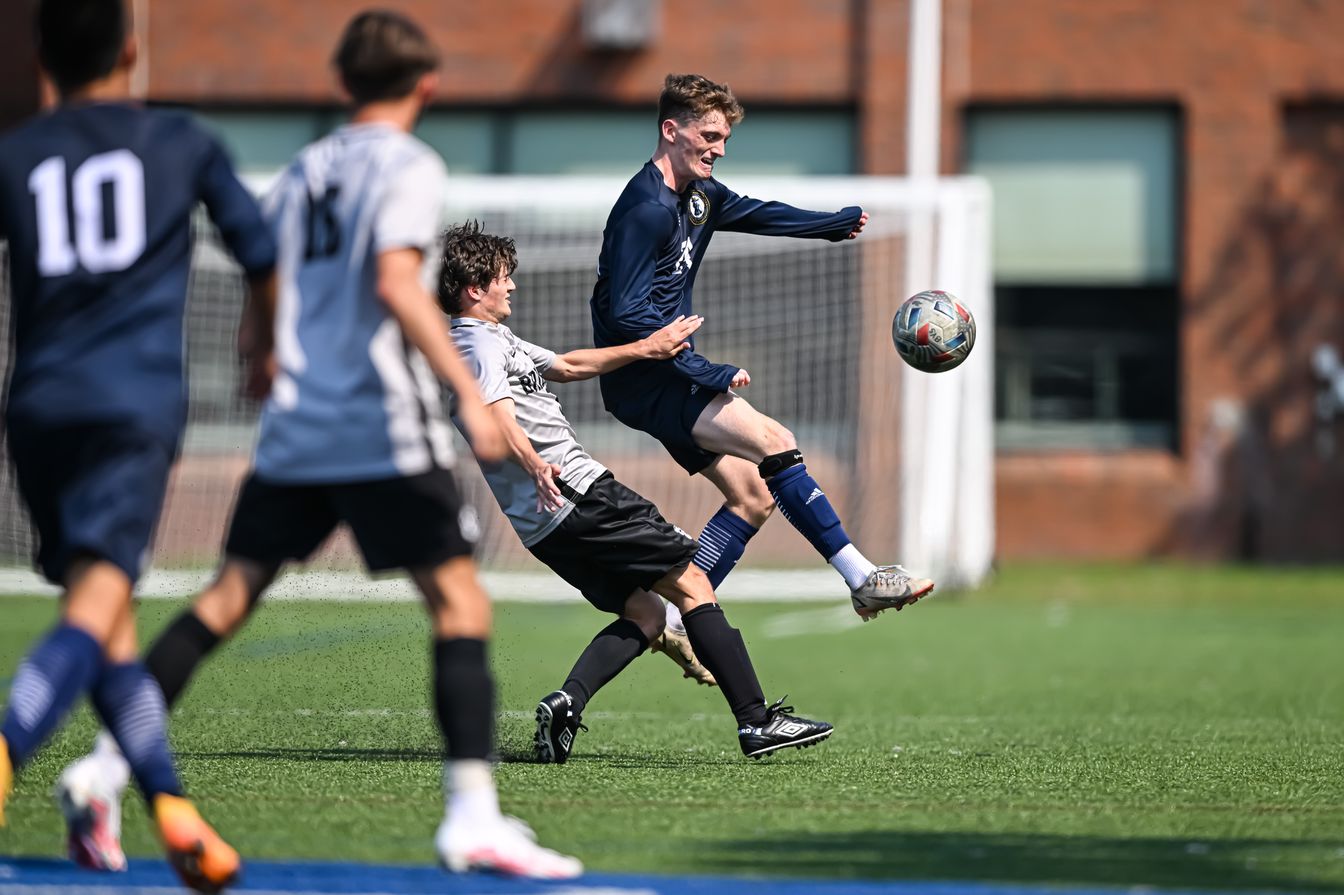 A soccer player jumps in the air to kick the ball.