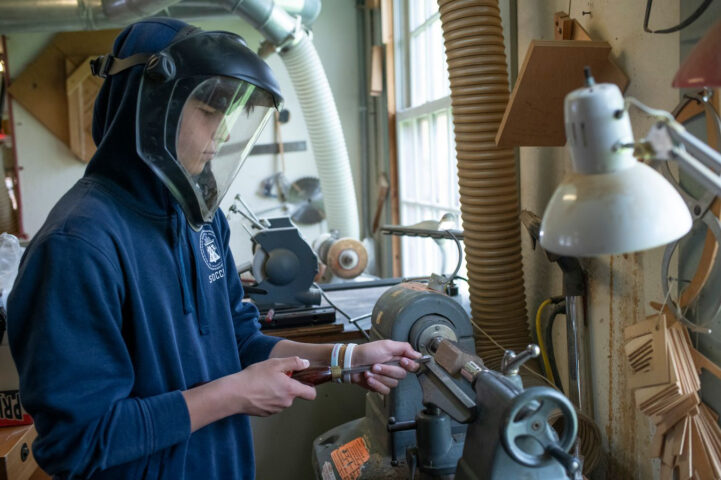 student turning wood on lathe.