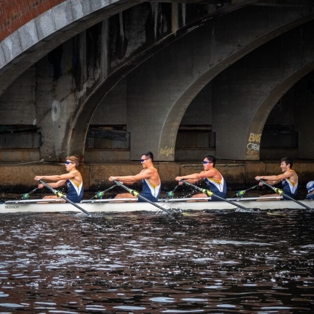 crew team on river under bridge.