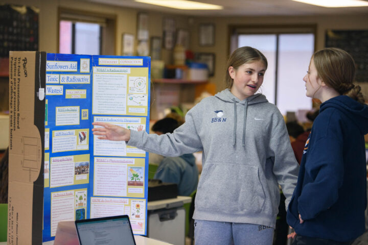 student presenting a project to another student.