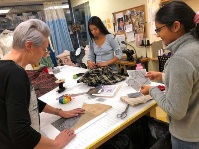 students working on costumes with teacher.