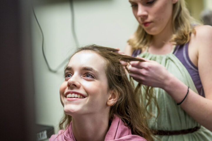 girl getting hair styled for stage performance.