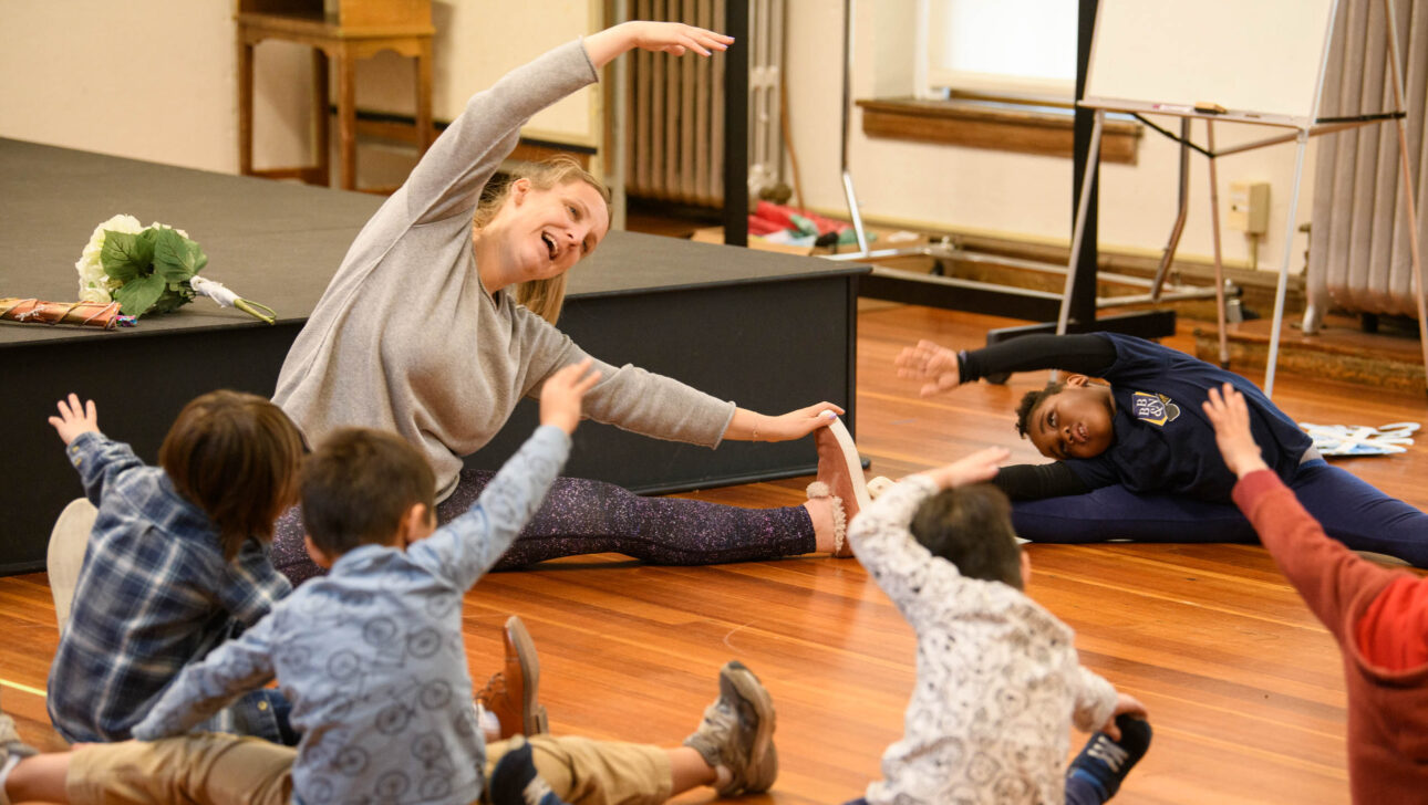 young students doing yoga with teacher.