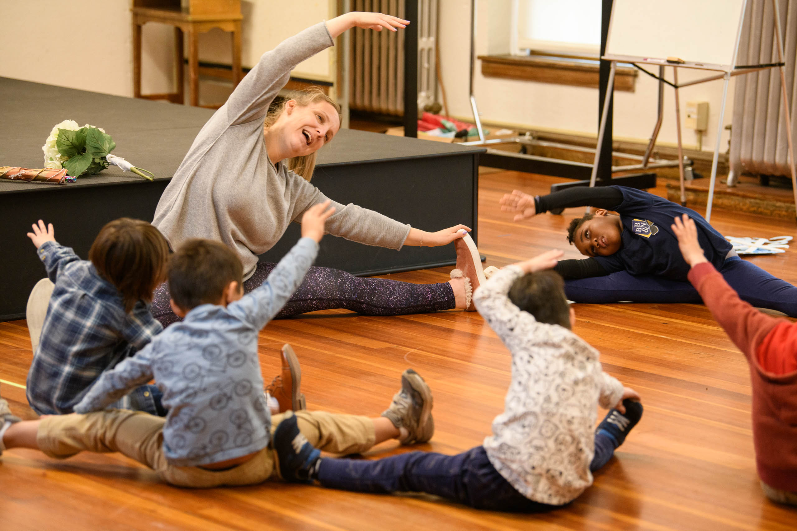young students doing yoga with teacher.