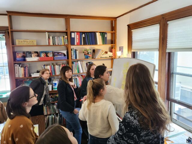 teachers having whiteboard discussion in office.