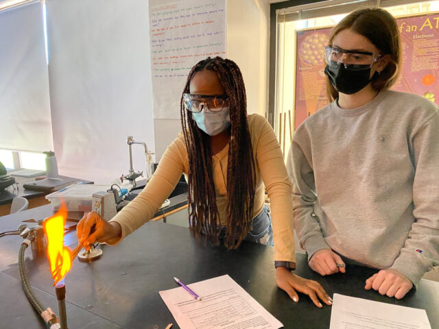 students using burner as part of science experiment.