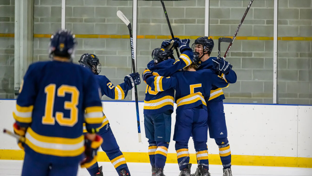 hockey team celebrating on ice.