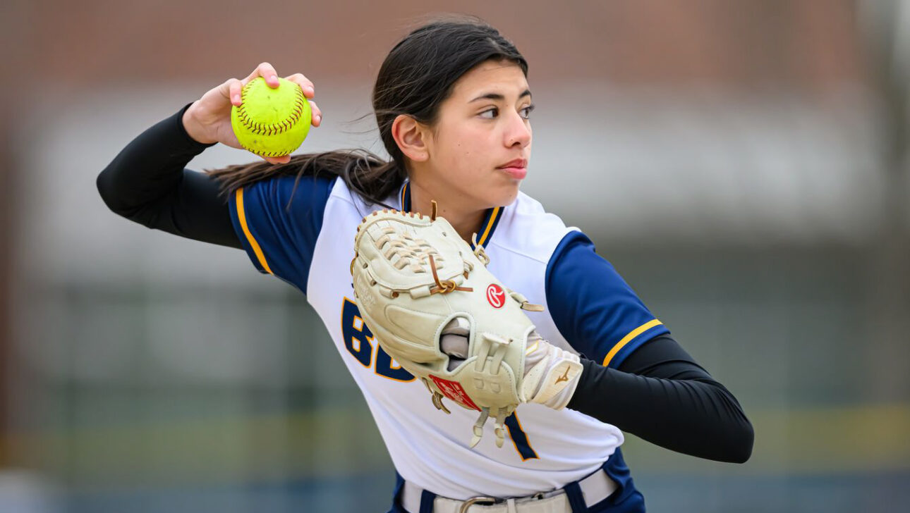 girl pitching softball.