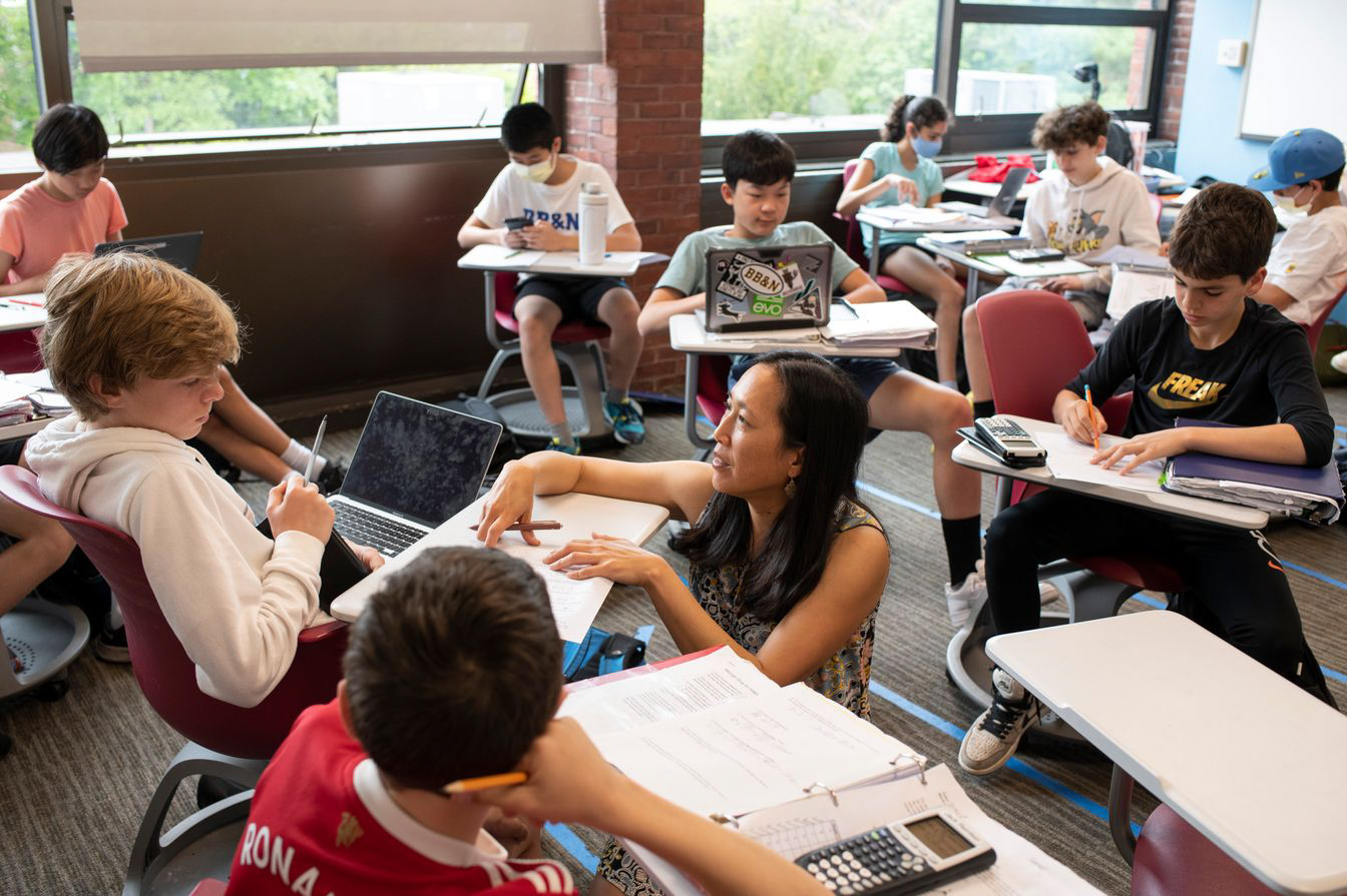 teacher helping students in class.