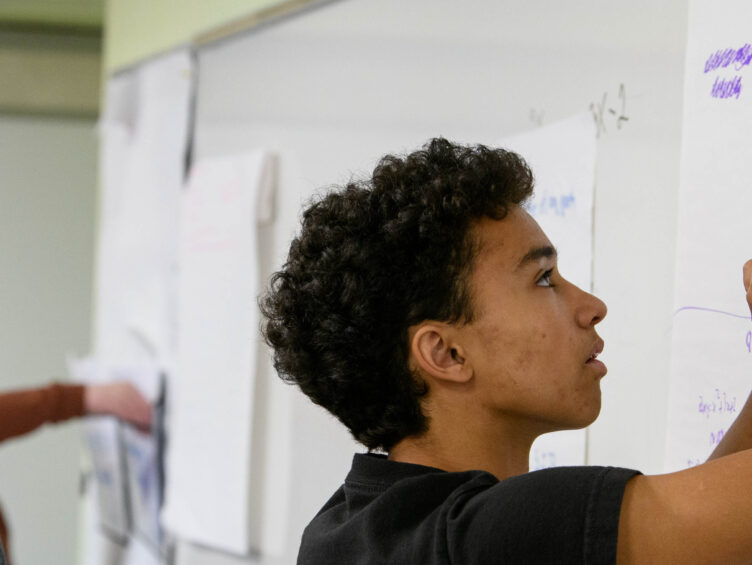 boy writing on whiteboard.