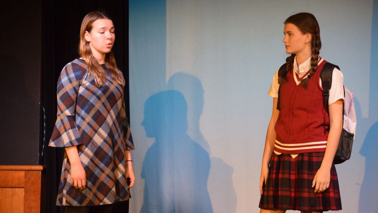 Two young women are standing on a stage.