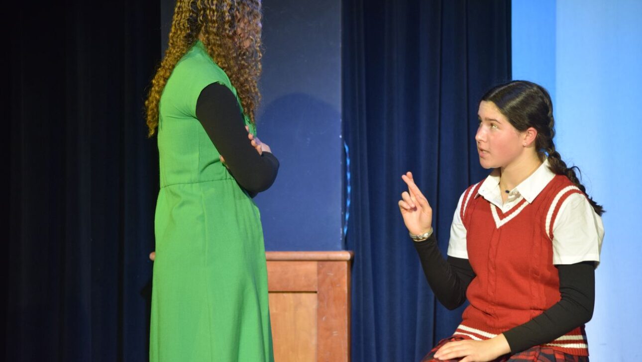 Two people are on stage in a theatrical performance.