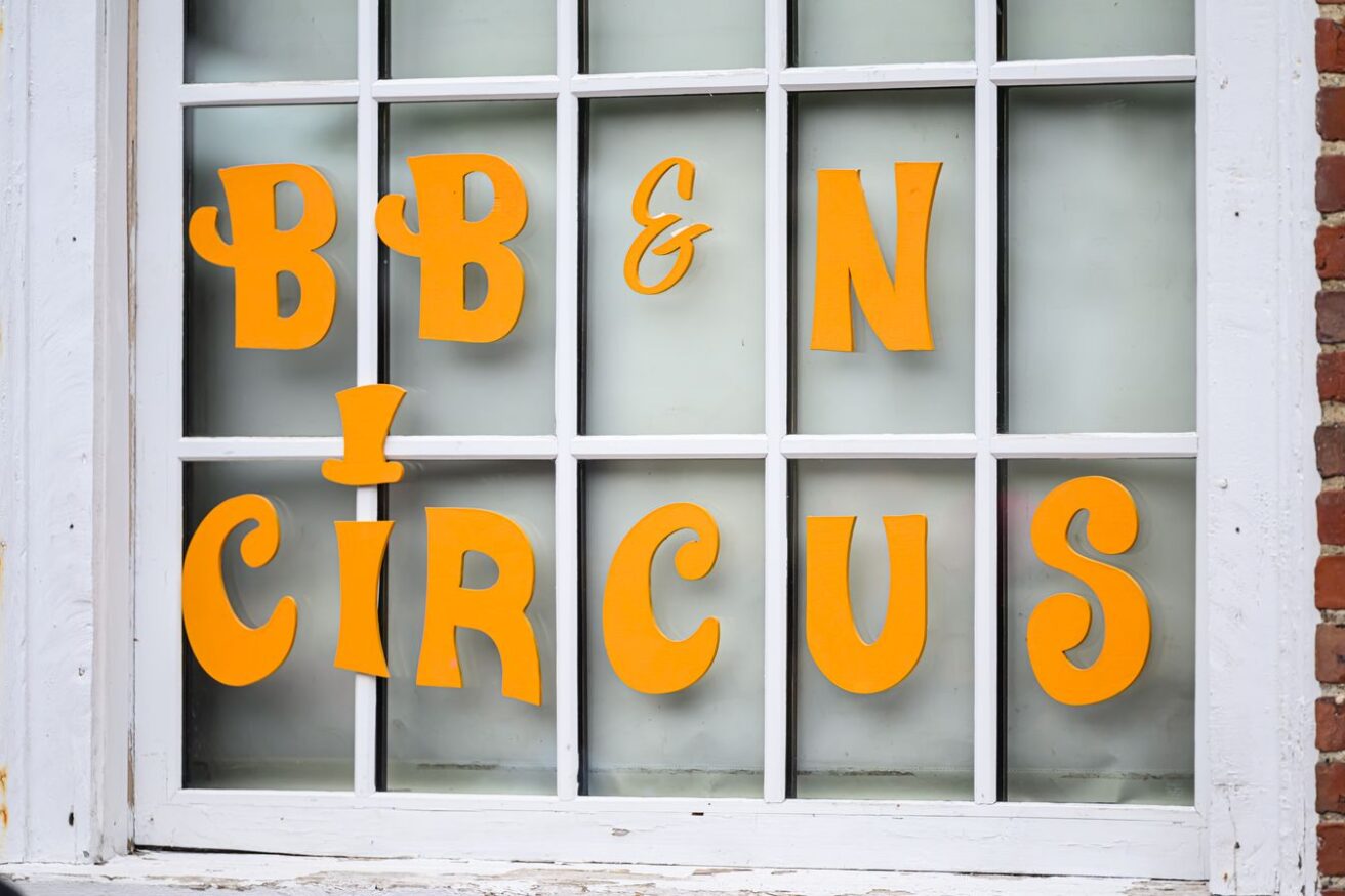 A window with yellow letters spelling "BB & N Circus" displayed on the glass panes.