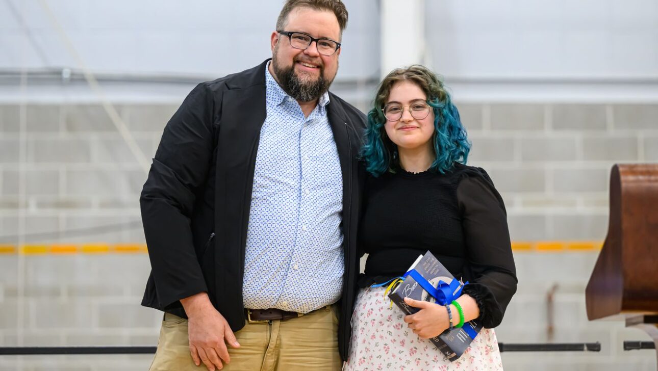 A man and a woman standing together indoors.