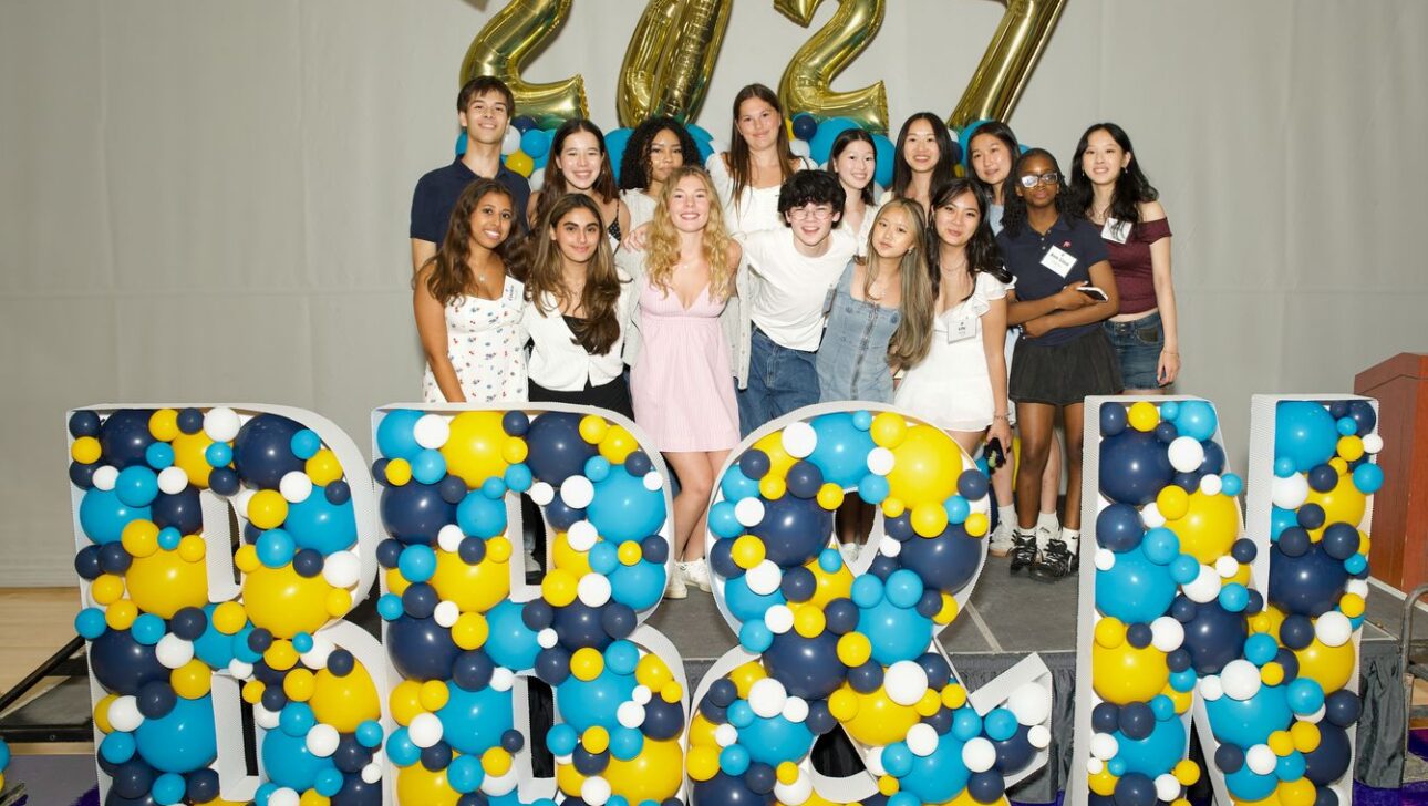 A group of teens poses in front of large BB&N balloon letters and gold 2027 balloons at an indoor event.